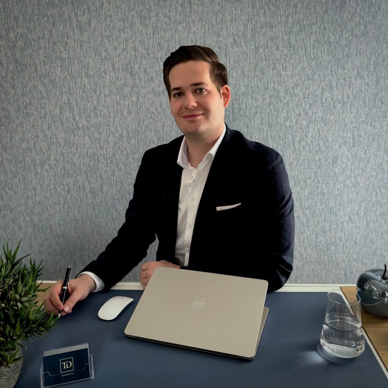 Steuerberater Tim Dahlke Steuerberater Tim Dahlke blickt am Schreibtisch lächelnd in die Kamera